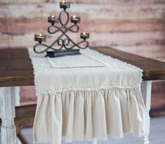 a table with candles on top of it and a white cloth draped over the table