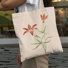 Our Designs Are Printed In-House On Sustainably Grown And Ethically Harvested Us Cotton. This Botanical Tote Features Vtg American Watercolor Art Of Blooming Lilium Philadelphicum Wildflowers, A Flowering Perennial Herb Species In The Lily Family, Liliaceae. The Flower Blossom Petals Are Depicted In Varying Shades Of Red, Orange, Yellow, White And Brown Surrounded By Green Leaves. Lilium Montanum Is Native To North America And Common Names Also Include Philadelphia Lily, Prairie Lily, Or Western Red Flower Tote, Prairie Lily, Red Lily, Watercolor Floral Print, Vintage Watercolor, Common Names, Red Orange Yellow, Print Graphic, Lily Flower