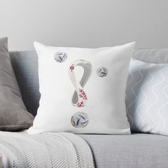 a white pillow sitting on top of a gray couch next to pillows and throw pillows