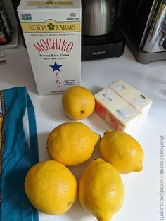 four lemons on a counter next to a carton of mochillo