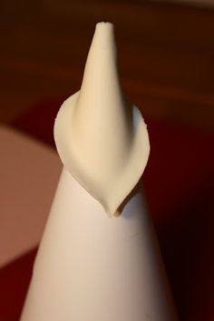 a white vase sitting on top of a red and white checkered tableclothed floor