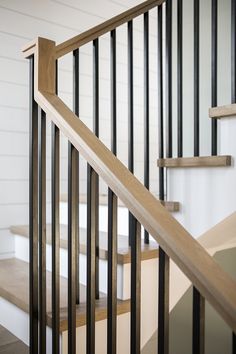 an image of a staircase with wood handrails and white walls in the background