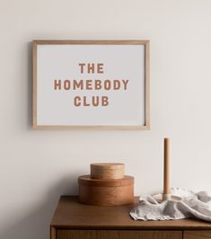 the home body club poster hangs above a dresser