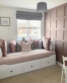 a window seat with many pillows on it