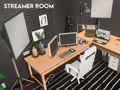 a computer desk with two monitors and a laptop on it, in front of a gray wall