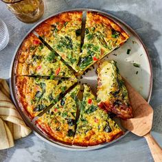 a pizza cut into eight slices on top of a pan with a wooden spatula