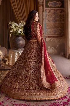 Red Bridal Lehenga and Choli Pakistani Wedding Dress is a stunning masterpiece that comes in premium quality fabric. Beautiful embroideries, motifs, sequins, and goldwork make this beautiful Pakistani Bridal Dress an epitome of beauty and your foremost priority to have a head-turning look. Lehenga Choli: The choli in an alluring red shade has long sleeves and is beautifully emblazoned with goldwork and embroideries. Dabka, naqshi, and gorgeous swarovski work make this beautiful choli a perfect c Bridal Lehenga Pakistani, Red Bridal Lehenga, Pakistani Bridal Lehenga, Red Lehenga Choli, Pakistani Bridal Dress, Red Bridal Dress, Raw Silk Lehenga, Bridal Dupatta, Bridal Dresses Pakistan