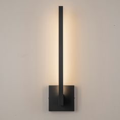 a black wall light with a dimmer on it's side against a white wall