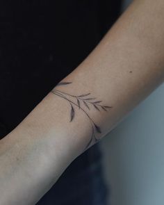 a woman's arm with a tattoo on it that has a plant growing out of it