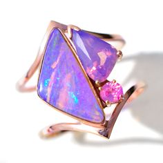 Opalescent Purple Sapphire and Purple  Australian Opal Symbiosis Ring in solid 14k Rose Gold. 23mm in length and 16mm wide. This mouthwatering pairing of purple Australian 3D wood replacement opal with blue fire, is paired with purple and pink opalescent sapphires- the peach tones of the sapphires pick up the pinkish t Opalescent Sapphire, Opal Ring Vintage, Peach Tones, Australian Opal Ring, Mid July, Unique Opal, Heirlooms Jewelry, July 18th, Purple Sapphire