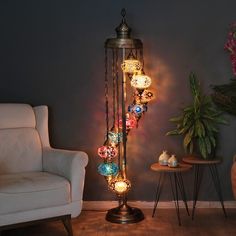 a lamp that is sitting on top of a table next to a chair and potted plant