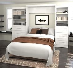 a white bed sitting in a bedroom on top of a hard wood floored floor