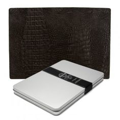 a white and black notebook sitting next to an alligator skin case