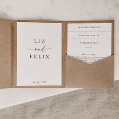 an open pocketfold wedding card with the word'liz and felix'printed on it