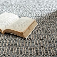 an open book sitting on top of a carpet