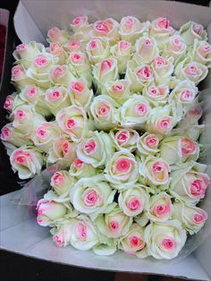 a bouquet of white and pink roses in a box