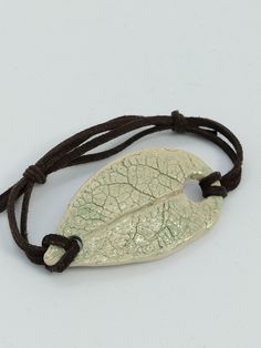 Bracelet made with a pretty cream and pale green enameled ceramic medallion. It has the shape of a leaf and the imprint of a leaf (about 6cms) It is mounted on a flat brown suede cord. Its maximum bracelet length is approximately 23.5 cm and is adjustable using slip knots. Ceramic Leaf, Brown Flats, Suede Cord, Green Ceramics, Pale Green, Brown Suede, Bracelet Making, Favorite Jewelry, Jewelry Bracelets