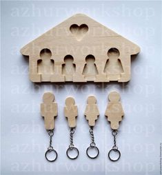 a wooden house with keychains attached to it and people in the shape of a family