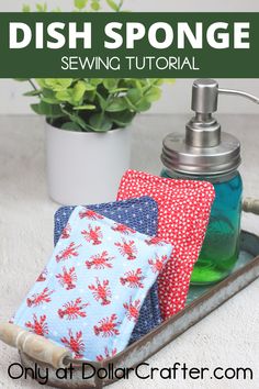 the dish sponge is sitting on top of a tray with some cloths and a soap dispenser next to it