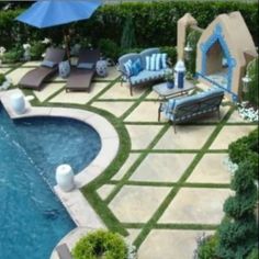 an outdoor pool with lounge chairs and umbrellas next to the swimming pool is decorated in blue and white