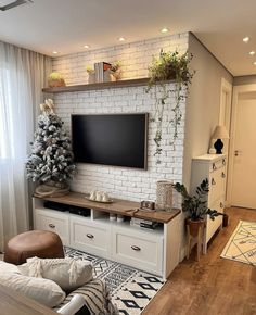 a living room with white brick wall and wooden flooring, decorated for the holidays