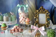 a table topped with lots of desserts and cupcakes