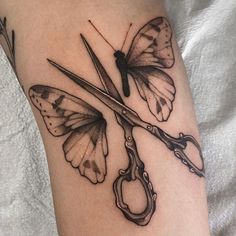 a tattoo with scissors and butterflies on it