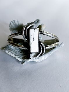 The White Buffalo gemstone, featuring a chic black and white palette, brings a touch of class and timeless elegance to this cuff. Designed with a vibrant movement pattern, the cuff features a deep patina for added depth and a high polish for ultimate shine. Embrace the simplicity and sophistication of winter with this versatile piece that effortlessly complements any look, day or night. MATERIALS White Buffalo Sterling Silver SIZE L Large. 6 inch cuff with a 1 inch gap; wrist circumference 7-7.5 inches Note: The cuff can be sized down to a smaller size for an additional $20 charge. Please contact me here; mention the product name and size! DIMENSIONSCenterpiece 1 and 1/2 inch tall Modern Sterling Silver Nickel-free Cuff Bracelet, Unique Nickel-free Sterling Silver Cuff Bracelet, Movement Pattern, Black And White Palette, The White Buffalo, Silver Artisan Multi-stone Cuff Bracelet, Southwestern Adjustable Multi-stone Cuff Bracelet, Unique Turquoise Nickel-free Cuff Bracelet, White Palette