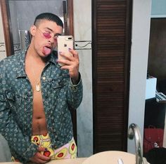 a man sticking his tongue out while taking a selfie in front of a mirror