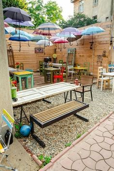 an outdoor patio with tables, chairs and umbrellas