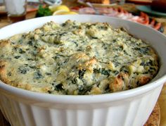 a casserole dish with spinach and cheese in it sitting on a table