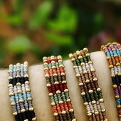 a close up of a person's arm wearing bracelets with beads on it