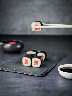 sushi with chopsticks on a slate board