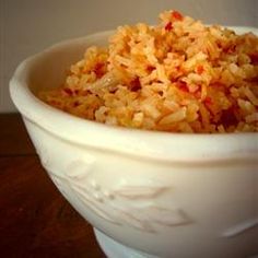 a white bowl filled with rice on top of a wooden table