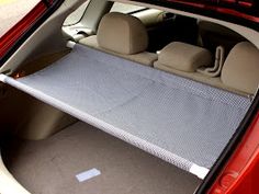 the back seat area of a car with an open hatchback door and gray carpet