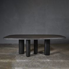 an oval table with three black pedestals on the top and one round in the middle