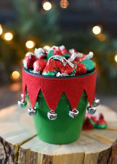 a green container filled with candy sitting on top of a tree stump