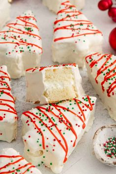 white cake with red and green sprinkles is cut in half on a plate