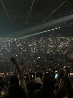 an audience at a concert with their cell phones up in the air and lights on