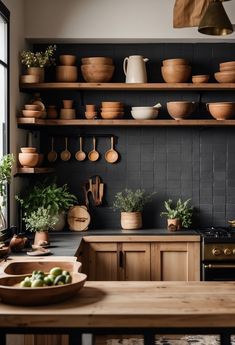 a kitchen with wooden shelves filled with pots and pans on top of the counter