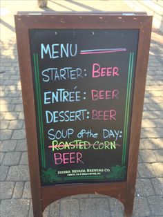 a menu board on the sidewalk for beer