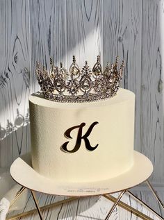 a white cake with a crown on top and the letter k on it's side