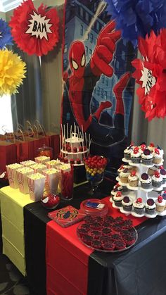 a spiderman themed birthday party with cupcakes, cake and desserts on the table