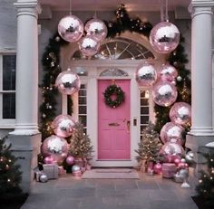 a pink front door decorated with christmas decorations