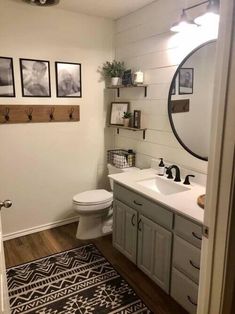 a bathroom with a sink, toilet and pictures hanging on the wall over the bathtub