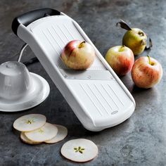 an apple slicer sitting on top of a counter next to sliced apples