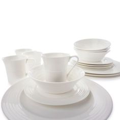 white dishes and cups are stacked on top of each other