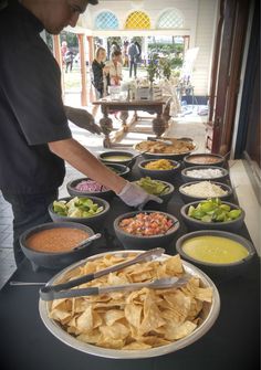 a man standing in front of a table filled with bowls and plates full of food