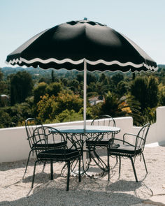 an outdoor table and chairs with an umbrella