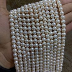 a hand holding a bunch of white pearls